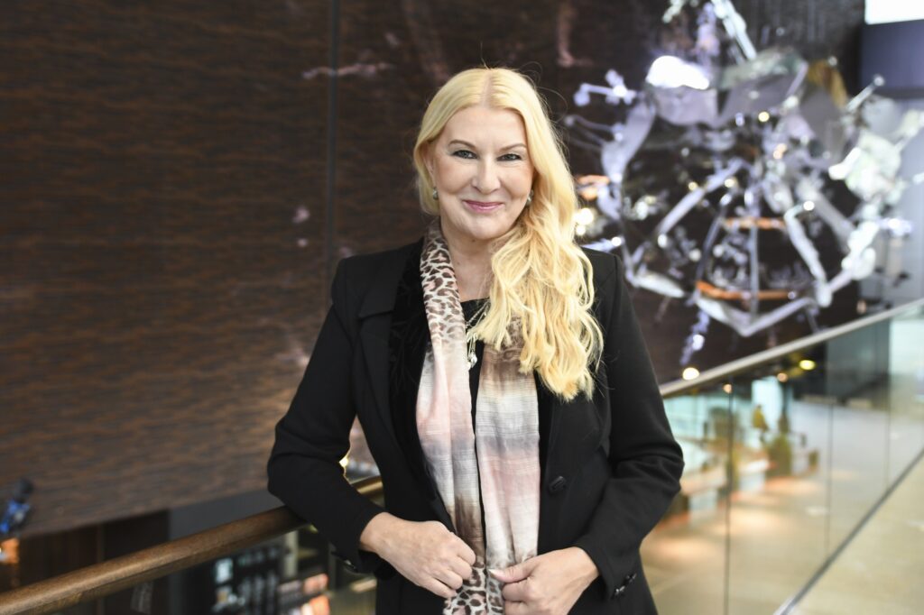Helena Åhman seisoo Musiikkitalon toisesa kerroksessa ja nojaa kaiseeseen.