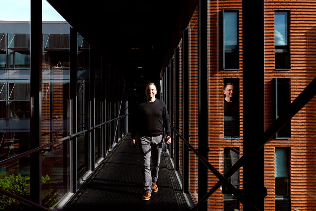 Peter Kenttä kävelee Aalto-yliopiston tuotantotalouden laitoksen käytävällä ja katsoo kameraan. T